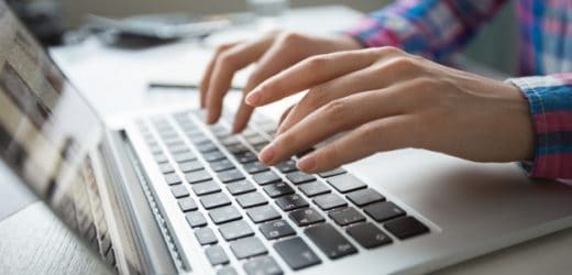 close up photo of hands typing on laptop