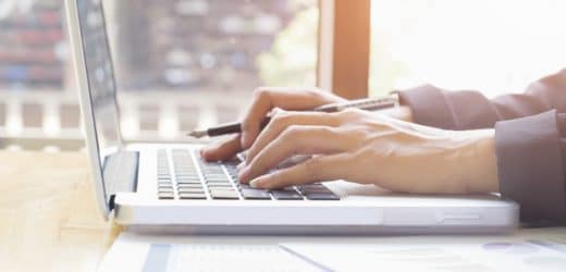 Business woman's hands typing on laptop keyboard